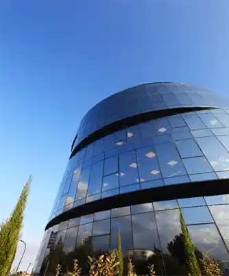 Modern curved building with glass facade and blue sky
